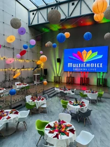 a room with tables and chairs and colorful lanterns